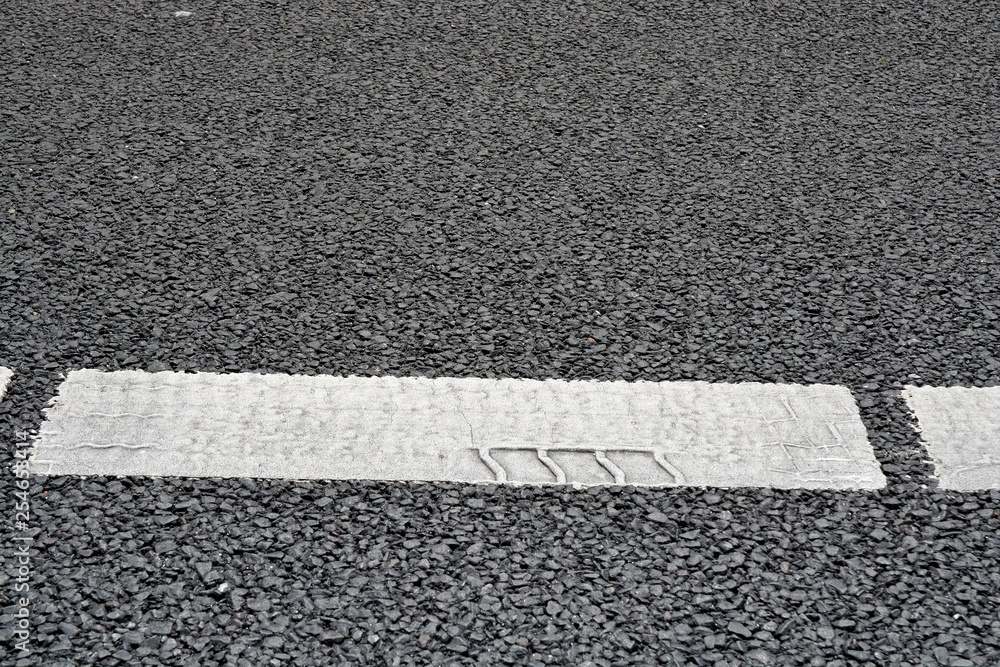 Fototapeta premium Asphalt road with marking stripes with tracking marks of tires