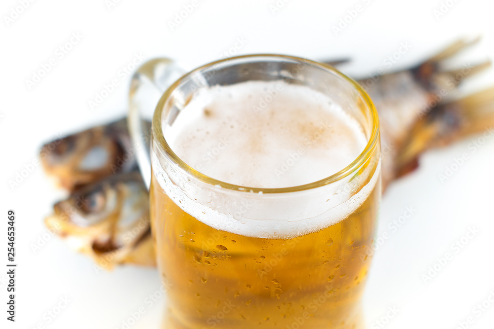 Traditional russian snack. A glass of beer and dried fish. White background. Traditional russian snack. A glass of beer and dried fish. White background.