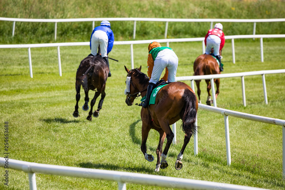 horse riders galloping on on the race track horse riders galloping on on the race track