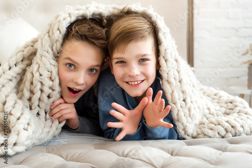 Photography Two cute brothers playing together at home, smiling and looking into the camera