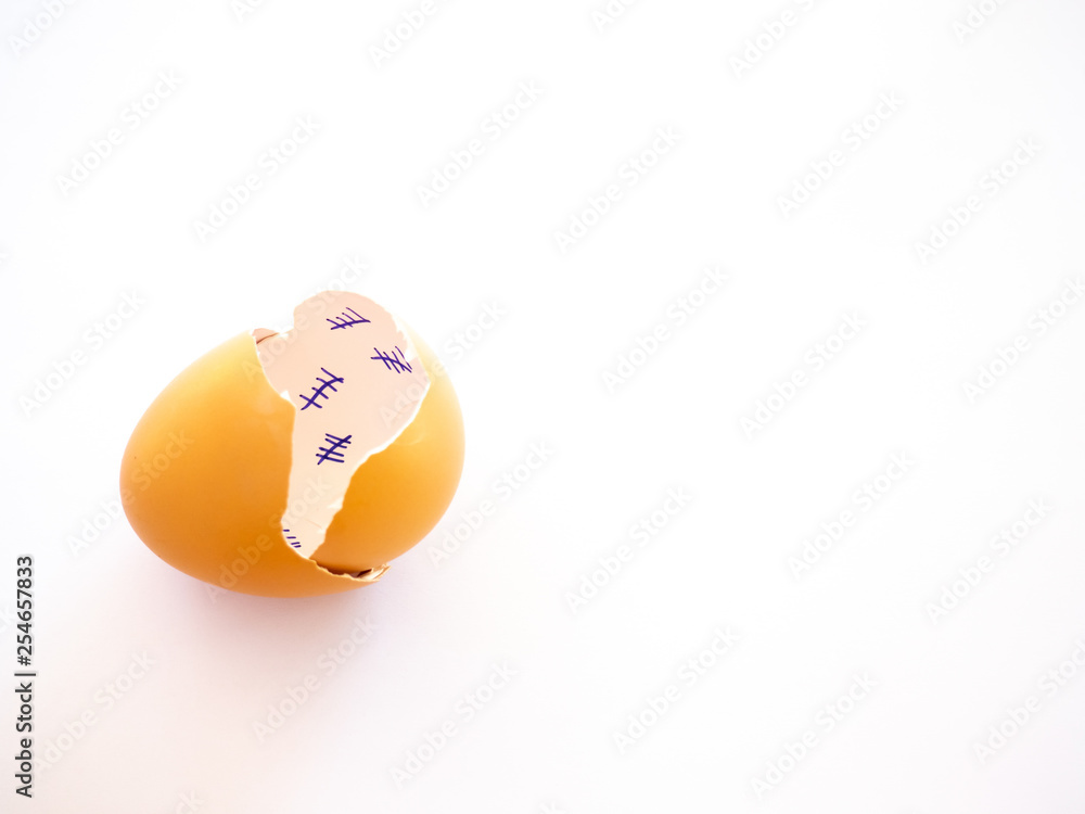 A broken egg with a countdown inside it and feather on a pastel blue background. Concept of freedom