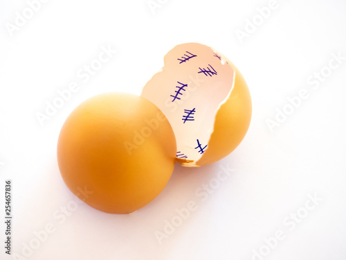 A broken egg with a countdown inside it and feather on a pastel blue background. Concept of freedom