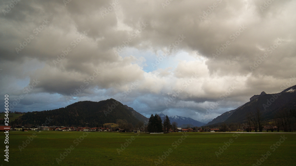 Fototapeta premium mountain meadow scenery with clouds and sunset