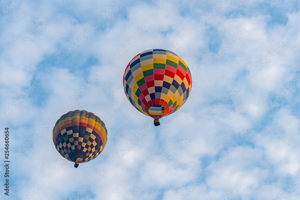 Fototapeta premium Colorful hot air balloons floating above the lake with blue sky in Singha Park ,Chiang Rai, Thailand.
