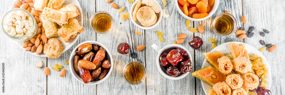 Set various Middle Eastern Arabian sweets - Turkish baklava, knafeh (kunaf), nuts, dried fruits and seeds. White wooden background, top view copy space banner Set various Middle Eastern Arabian sweets - Turkish baklava, knafeh (kunaf), nuts, dried fruits and seeds. White wooden background, top view copy space banner