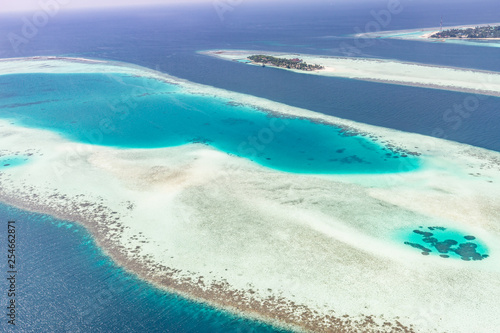 Fototapeta Naklejka Na Ścianę i Meble -  Aerial view of Maldives atolls is the world top beauty. Maldives tourism. Exotic aerial landscape in Maldives islands
