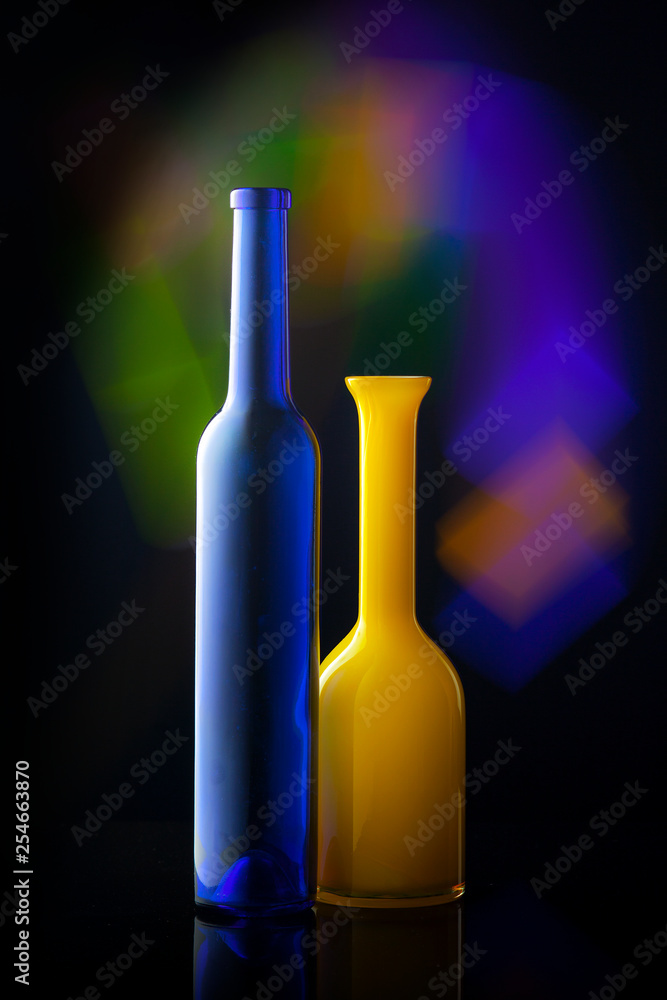 two bottles minimalism, blue and yellow bottles on dark background with multicolor lights, bright colors two bottles minimalism, blue and yellow bottles on dark background with multicolor lights, bright colors