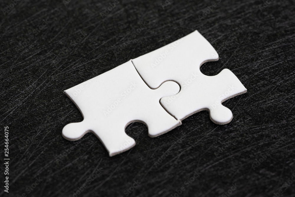Obraz premium Closed up of white jigsaw puzzle on dark black background using as answer, solution, completion or strategy for business success