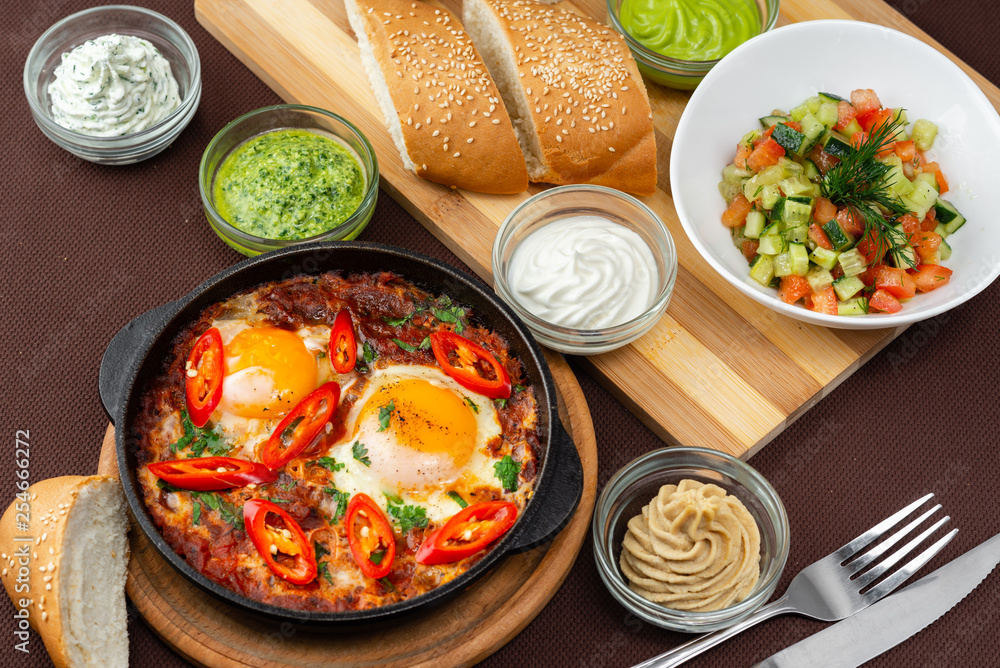 shakshuka in the pan and food on a table shakshuka in the pan and food on a table
