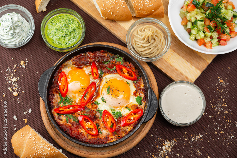 shakshuka in the pan and food on a table shakshuka in the pan and food on a table