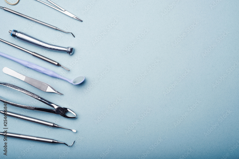 Dental steel instruments on light blue background with copy space Dental steel instruments on light blue background with copy space