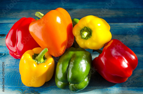 paprika pepper yellow orange red green close up on blue wooden background