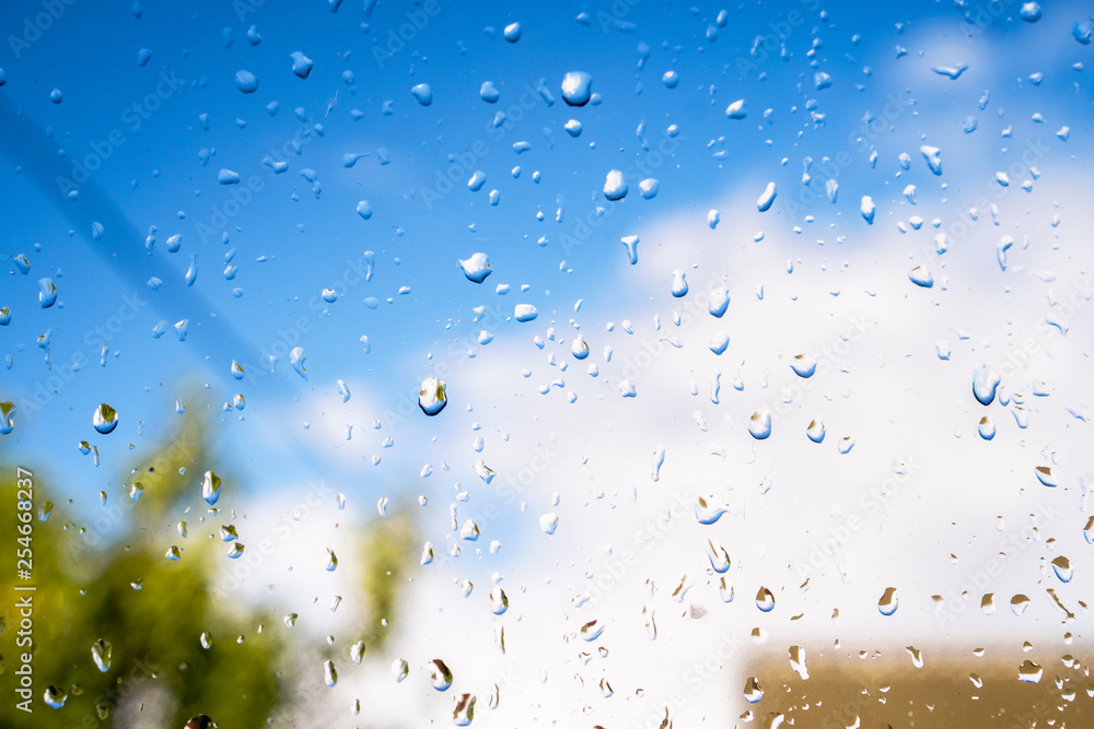 Beautiful raindrops on the window glass. Spring summer weather with warm rain. Stock photo