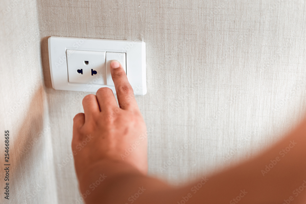 Woman Hand is Turning Switch On for Electric Light in a Bedroom, Close-Up of Fingers Woman is Pressing Button Power Light. Woman Hand is Turning Switch On for Electric Light in a Bedroom, Close-Up of Fingers Woman is Pressing Button Power Light.