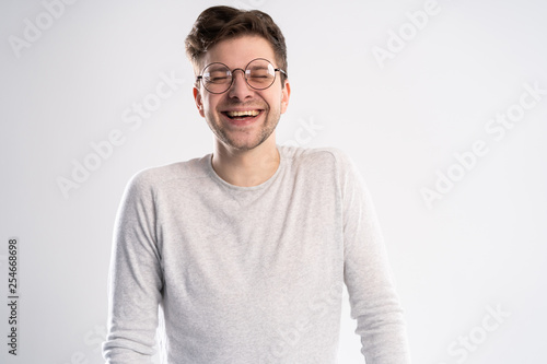 Best smile you ever saw. Portrait of handsome young man looking at camera with smile while standing against white background.