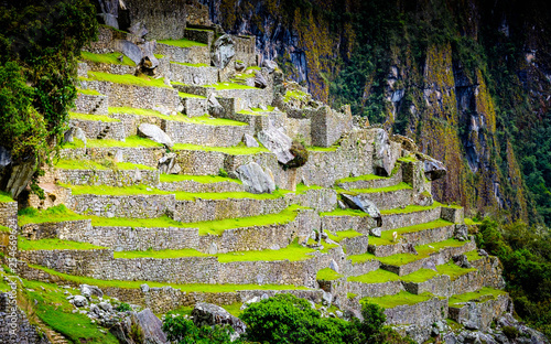 Amazing scenery of majestic ancient stone Machupicchu temple covered with grass on the background of rocky mountain photo