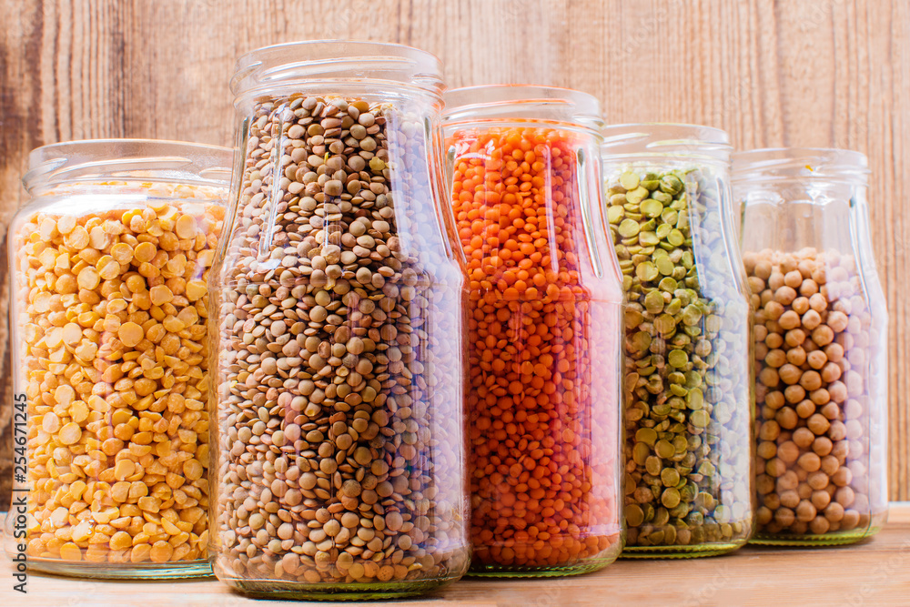 Collection set of beans, pulses, peas, lentils in glass jars on wooden background Collection set of beans, pulses, peas, lentils in glass jars on wooden background
