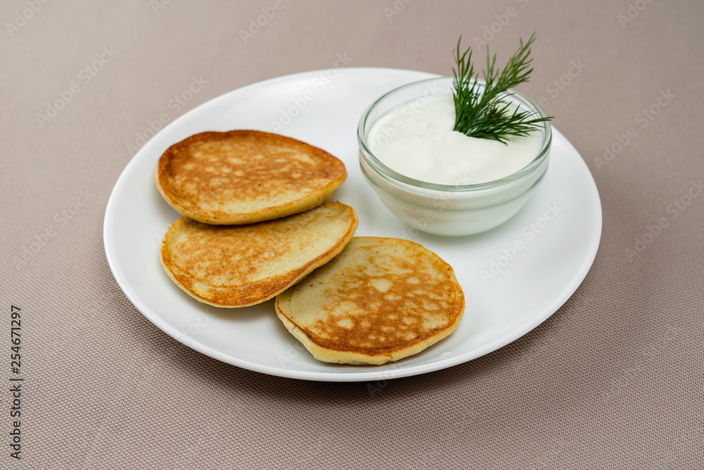 pancakes with sour cream in a white plate