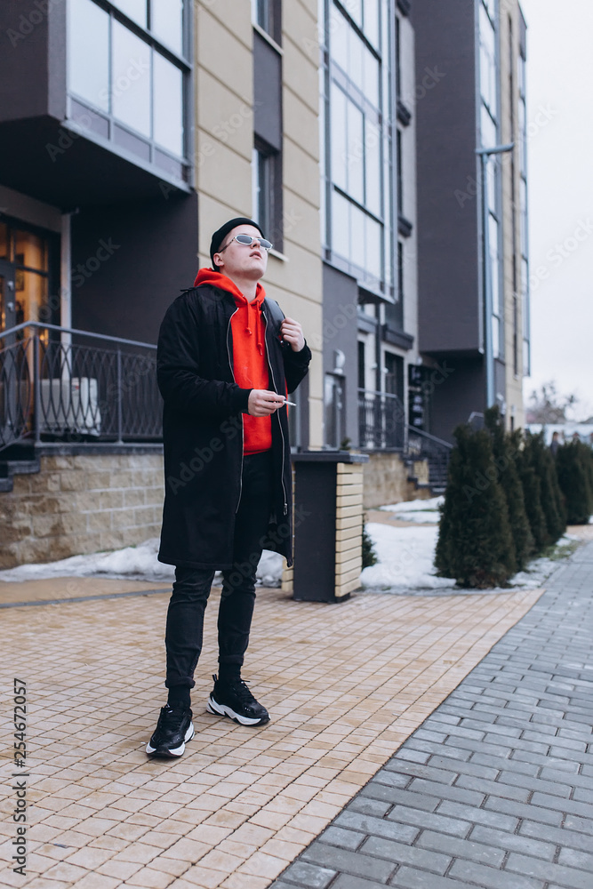 Free handsome independent man walking on street of modern luxury district with backpack in fashionable sun glasses. Freedom,traveller, leader man concept