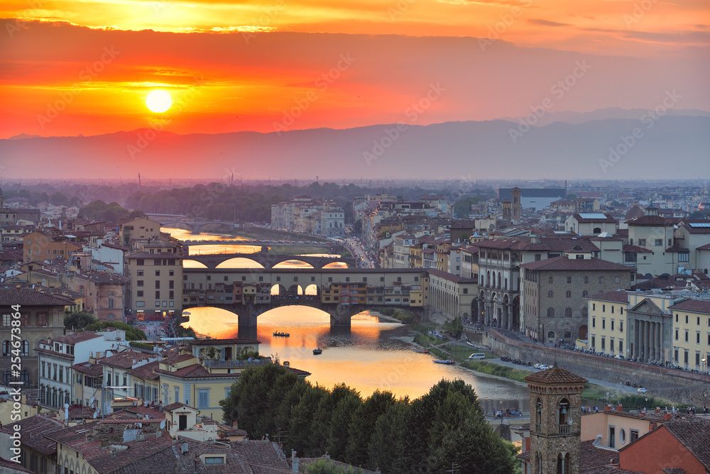 View of the River Arno and famous bridge Ponte Vecchio. Amazing evening golden hour light. Beautiful gold sunset in Florence, Italy