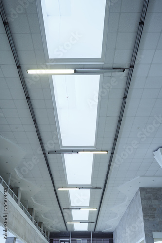 Lights in long line on ceiling of the office industrial building. Ceiling construction