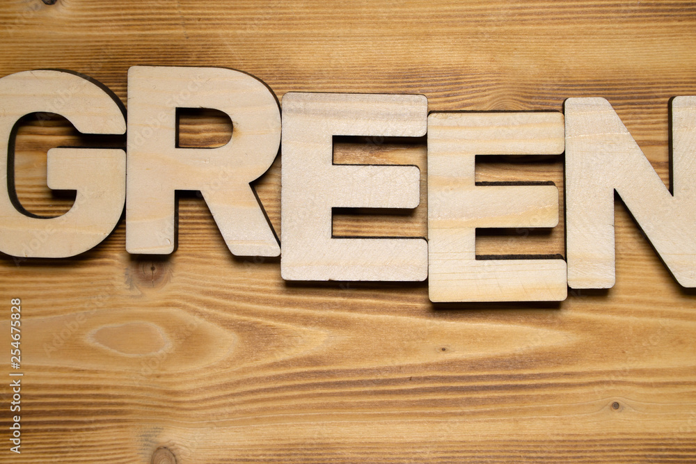 GREEN word made of wooden block letters on wooden board, top view. GREEN word made of wooden block letters on wooden board, top view.