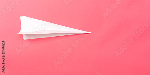 A paper plane on a pink paper background