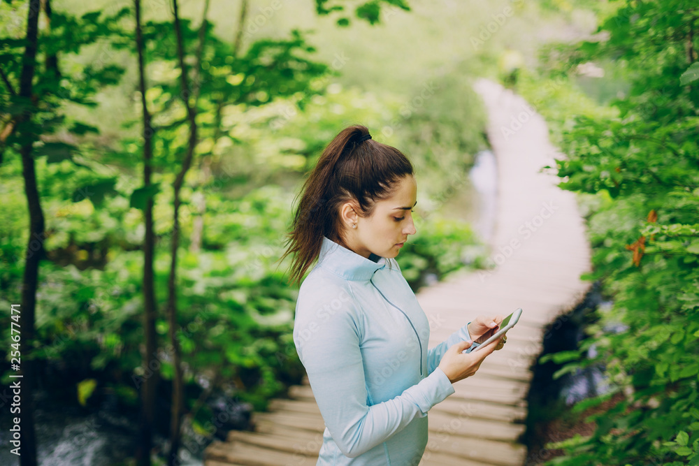beautiful girl in a tracksuit walking in green forest beautiful girl in a tracksuit walking in green forest