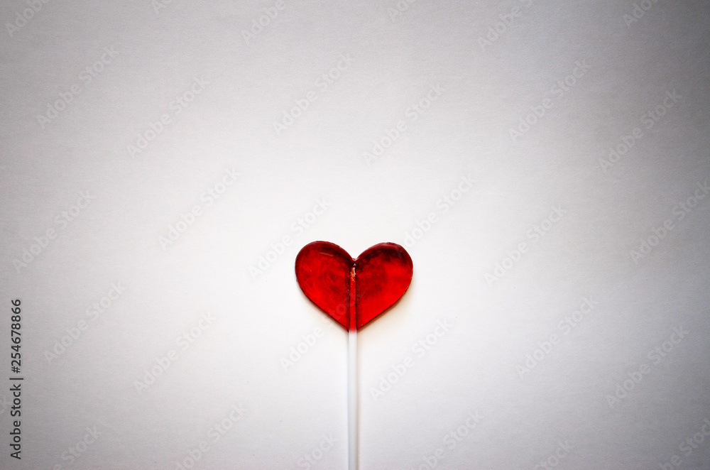 red heart shaped Lollipop on light background