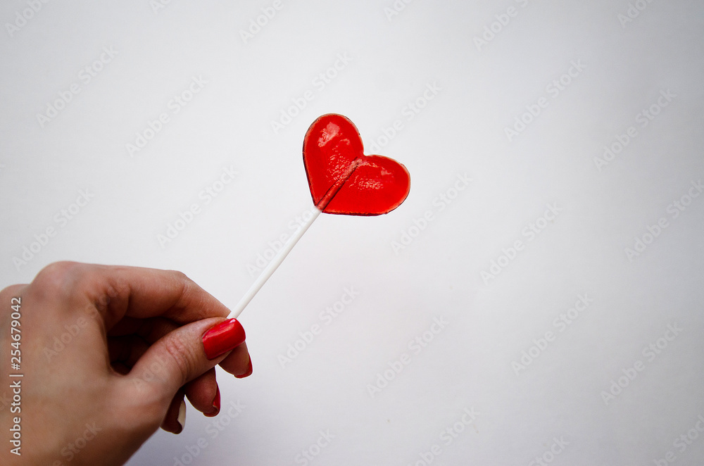 red heart shaped Lollipop on light background