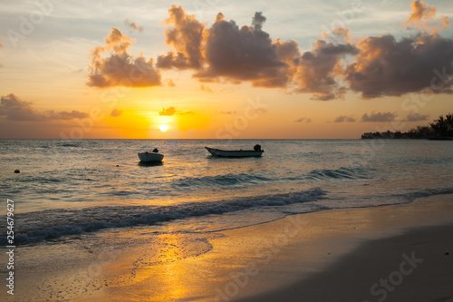 Worthing beach in Barbados at sunset. Two boat in the foreground