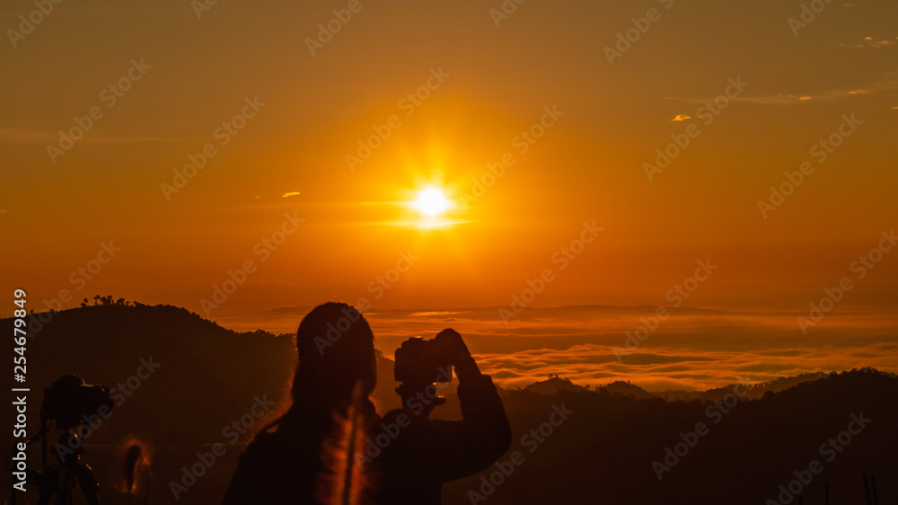 silhouette landscape at morning time tourist take pictures of the sunrise and mist on the mountain