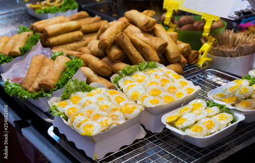 traditional thai food, fried quail eggs and spring rolls in the street of Thailand