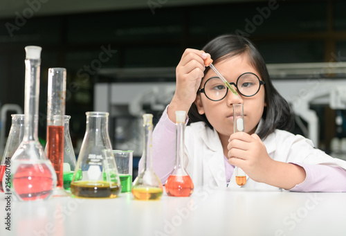 little scientist in lab coat making experiment