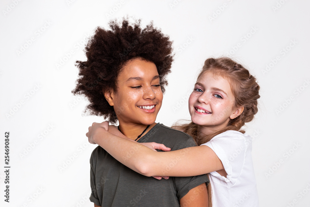 Pleasant dark-haired boy with wild hairstyle looking on his girlfriend Pleasant dark-haired boy with wild hairstyle looking on his girlfriend