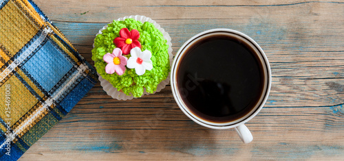flower spring cupcake with hot coffee cup on wooden table