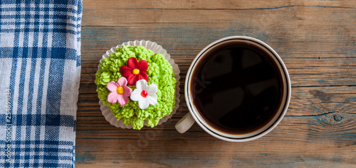 flower spring cupcake  with hot coffee cup on wooden table