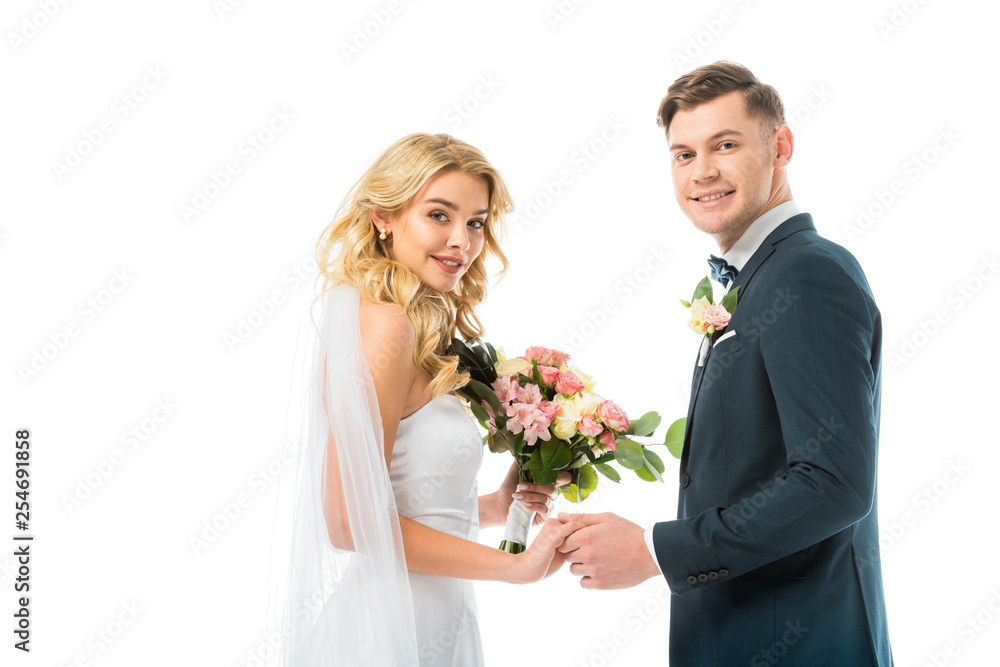 beautiful bride and handsome groom holding hands and looking at camera isolated on white beautiful bride and handsome groom holding hands and looking at camera isolated on white