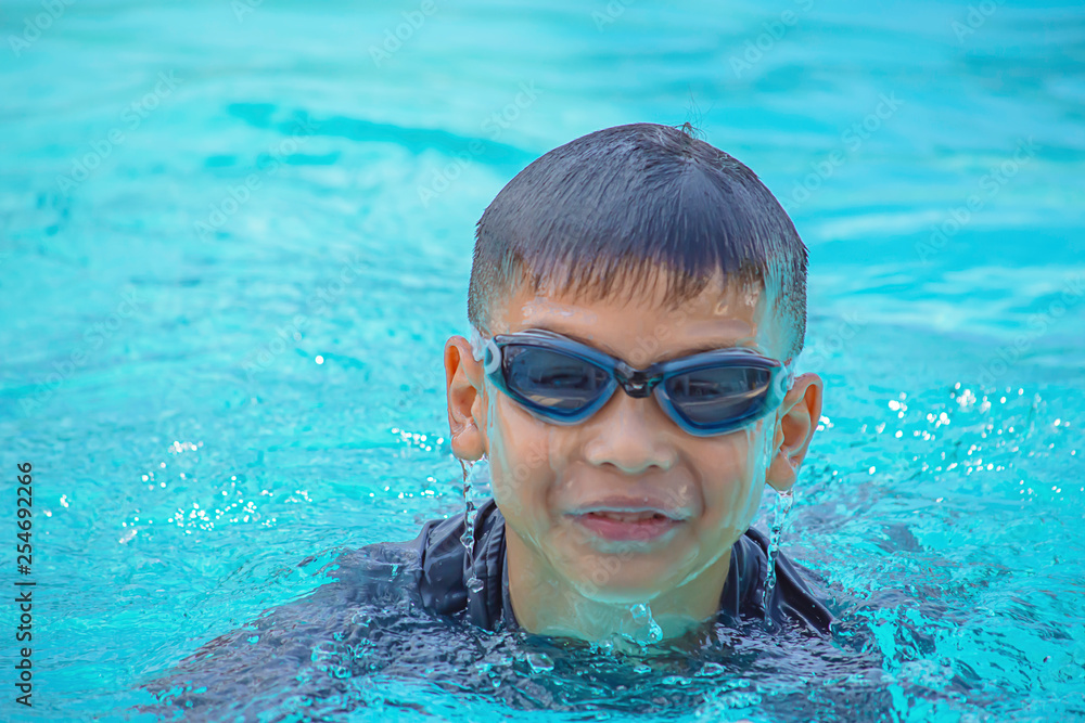 Naklejka premium Asian boy learned to swim in the pool.