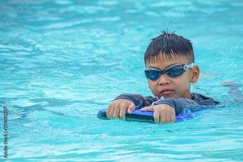 Asian boy learned to swim in the pool.
