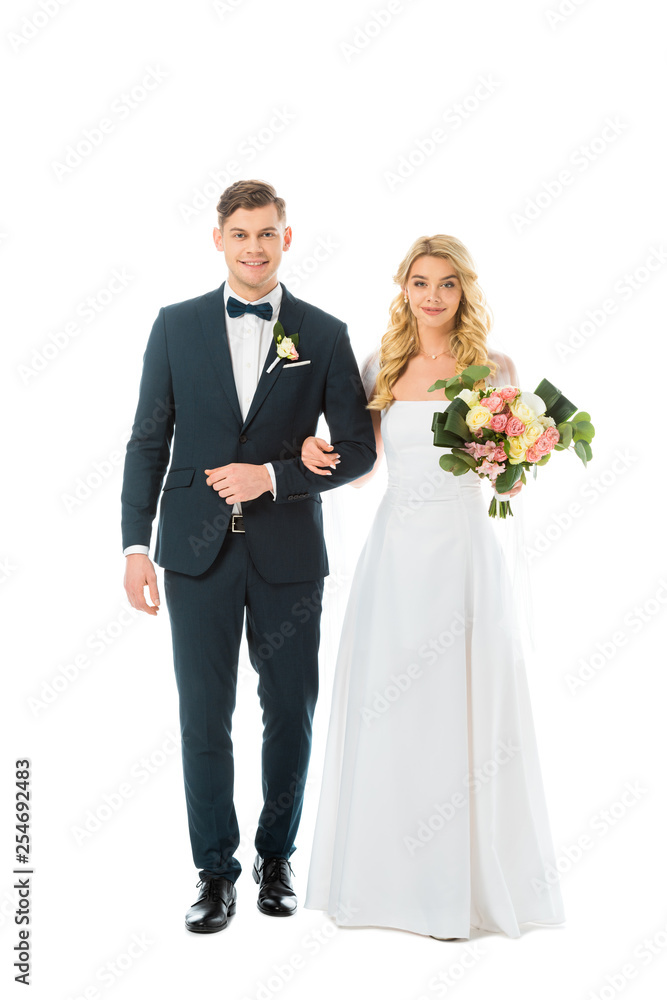 beautiful bride in white wedding dress, and handsome groom in elegant suit looking at camera isolated on white beautiful bride in white wedding dress, and handsome groom in elegant suit looking at camera isolated on white