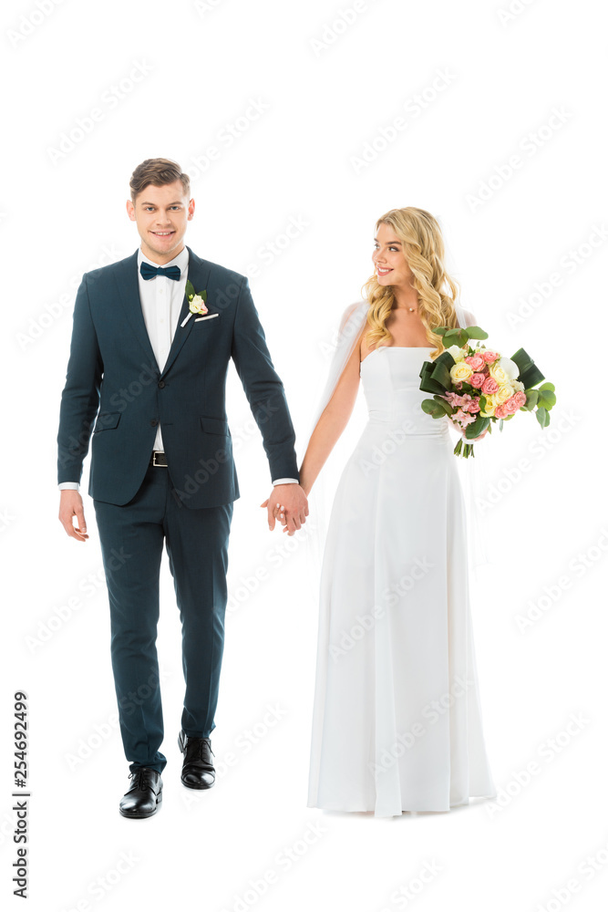 attractive bride in white wedding dress holding hands with handsome groom in elegant suit isolated on white attractive bride in white wedding dress holding hands with handsome groom in elegant suit isolated on white