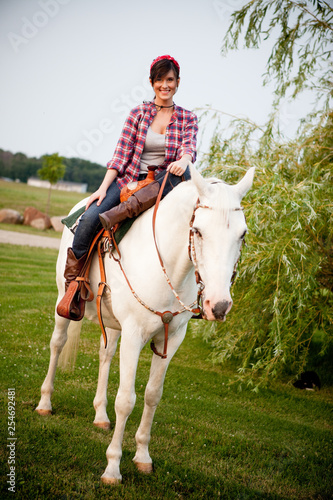 Young Woman Cowgirl Riding White Horse Outside © IdeaBug, Inc.