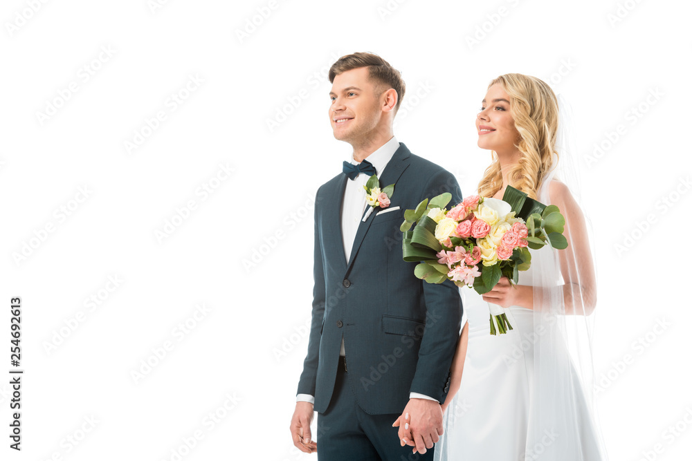 happy bride with beautiful wedding bouquet holding hands with smiling groom isolated on white happy bride with beautiful wedding bouquet holding hands with smiling groom isolated on white