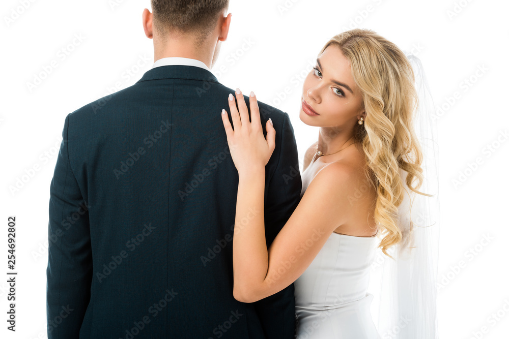 beautiful bride with blonde hair standing near groom and looking at camera isolated on white beautiful bride with blonde hair standing near groom and looking at camera isolated on white