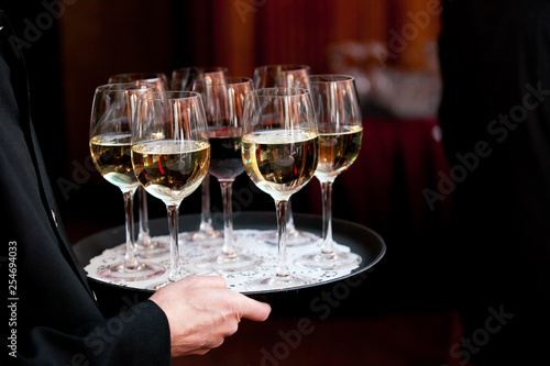 A waiter holding a tray full of drinks during a catered wedding or other special event