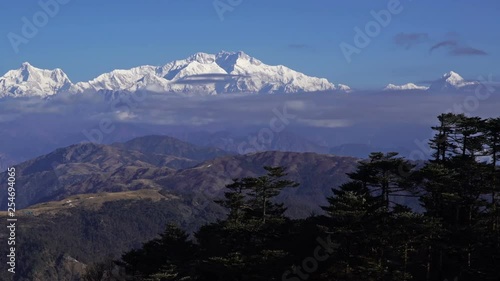 Kangchenjunga mount Time lapse wide angle of fog moving in front of mountain at blue sky day, Zoom in.