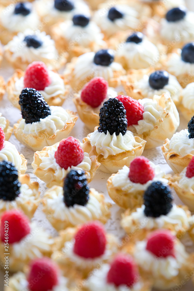 details of wedding treats with white cream and black berries and raspberries details of wedding treats with white cream and black berries and raspberries