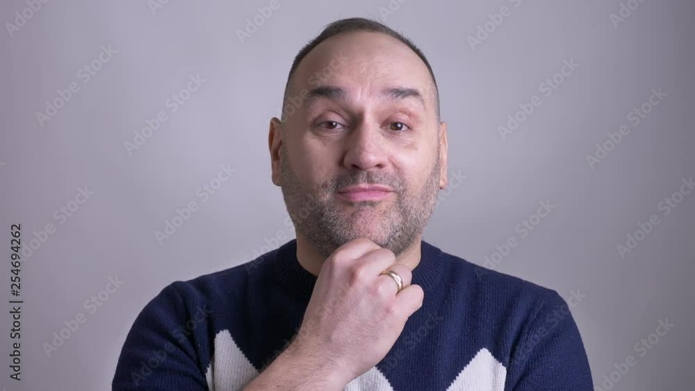 Closeup shoot of middle aged caucasian man being thoughtful getting an idea and smiling looking at the camera Closeup shoot of middle aged caucasian man being thoughtful getting an idea and smiling looking at the camera