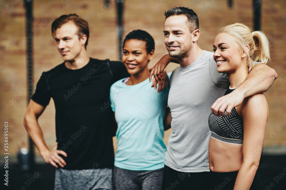 Smiling group of diverse friends standing together in a gym Smiling group of diverse friends standing together in a gym